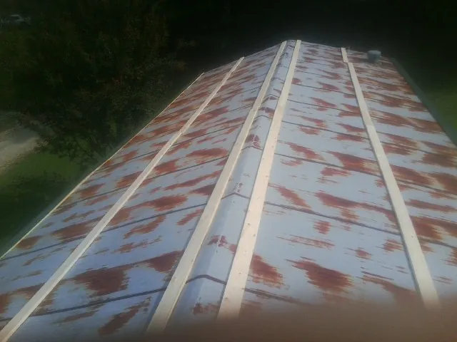 Rusted metal roof panels with new wood purlins before replacement — Storm Damage Roof Repair in Clive by Roofing Brothers